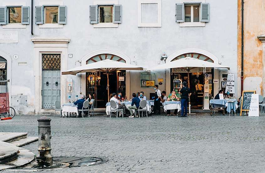 Pessoas em mesas de restaurante ao ar livre em Testaccio, um dos bairros onde ficar em Roma