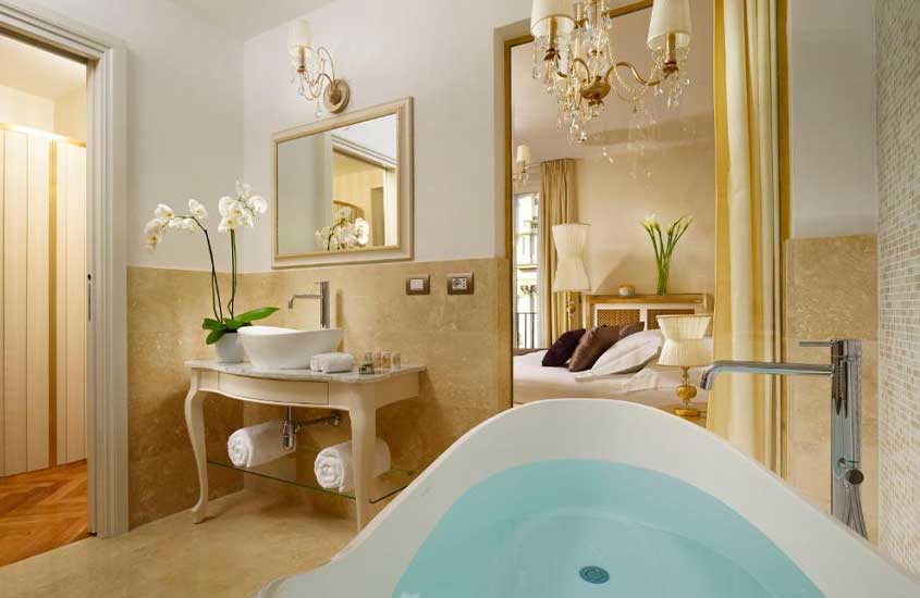 banheiro luxuoso de um dos hotéis em Roma, decorado com flores, banheira e mobílias em tons suaves