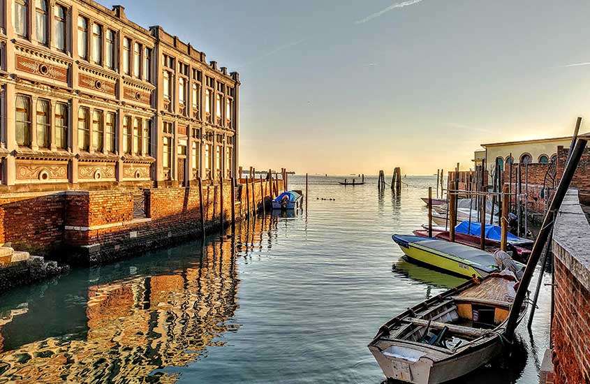 Durante um dia ensolarado, barquinhos estacionados em um mar de Giudecca, uma ilha em Veneza.