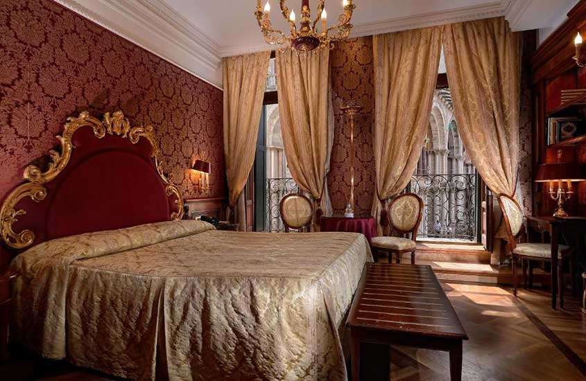 Quarto de hotel luxuoso equipado com cama de casal, poltronas e mesa.