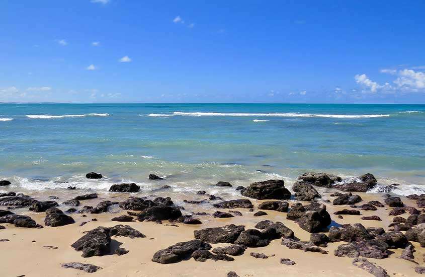 Vista panorâmica de pedras em frente ao mar de Pipa, uma das melhores praias do nordeste para viajar.