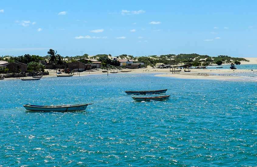 Vista panorâmica de pequenos barcos navegando no mar, iluminados pelos raios do sol em uma das praias mais bonitas do nordeste brasileiro.