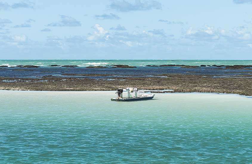 Vista panorâmica de pequeno barco em mar de Maragogi.