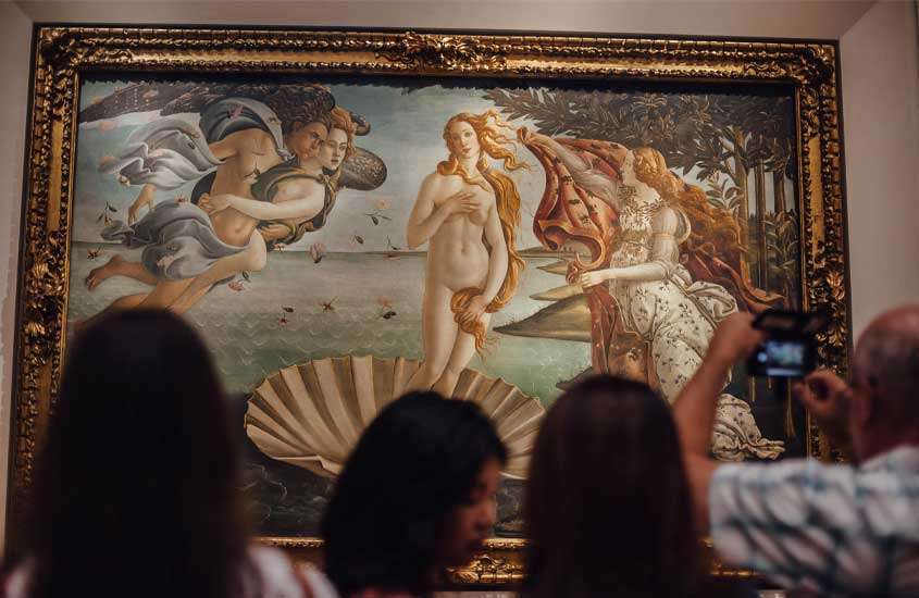 Pintura da Vênus de Botticelli, mostrando a icônica obra de arte renascentista que retrata a deusa Vênus, sendo admirada em museu
