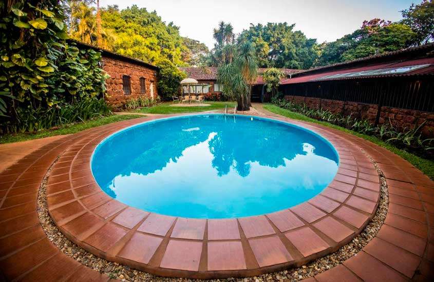 Em final de tarde, vista panorâmica de árvores ao redor de piscina ao ar livre em um dos hotéis fazenda em Minas Gerais