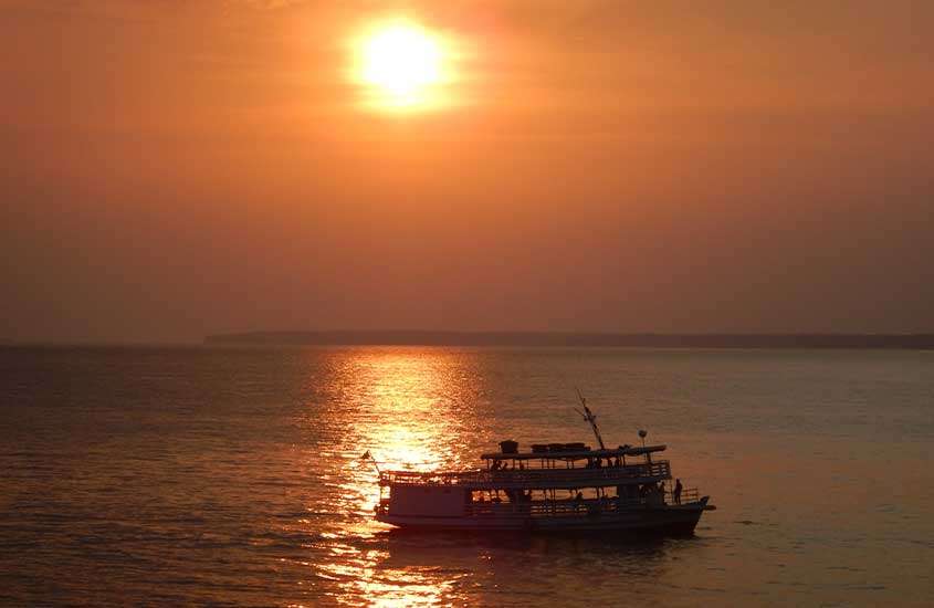 ao cair do sol, barco em mar de Manaus, uma das cidades mais bonitas do brasil
