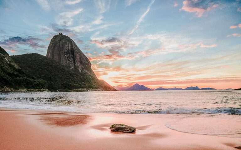 pôr do sol no Rio de Janeiro com vista do Pão de Açúcar à margem do mar