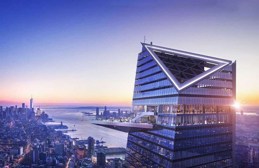Durante o entardecer, vista panorâmica da cidade e do mar de Nova Iorque com grande edifício espelhado a direita
