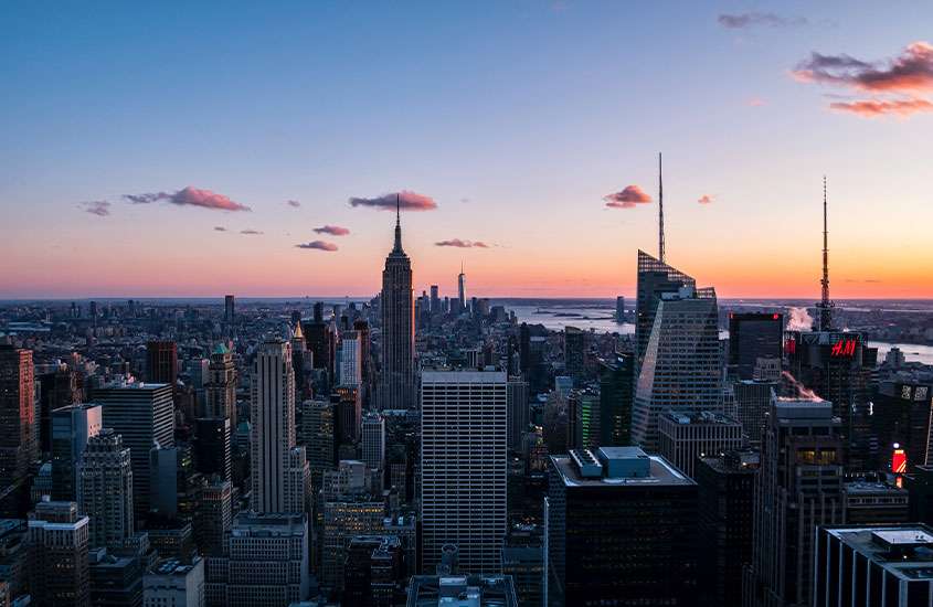 ao entardecer, vista panorâmica da cidade e do mar de Nova York com algumas nuvens no céu