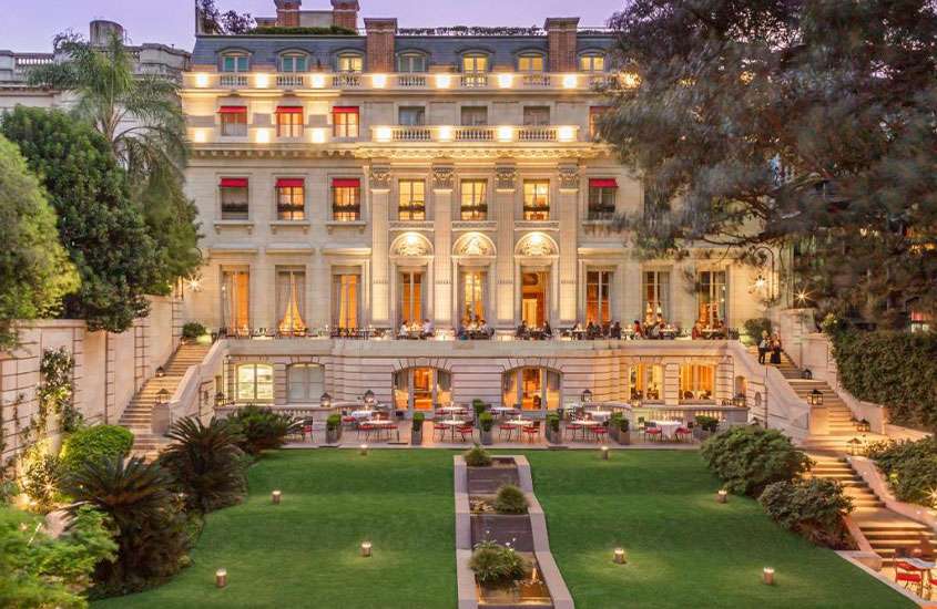 Jardim em frente a fachada iluminada e imponente de palácio de Duhau, um dos melhores hotéis para passar o réveillon em buenos aires