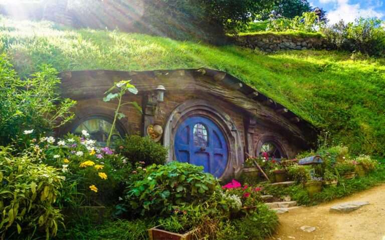 Durante dia de sol, casa de personagem famoso do filme Senhor dos anéis com grama e plantas ao redor