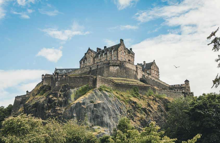 Durante o dia, castelo no topo de montanha cercada por muralha, em Old Town, um lugar onde ficar em Edimburgo
