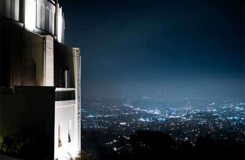 Durante a noite, Griffith Observatory cenários de filme La la land, na Califórnia, com cidade iluminada no fundo e árvores em volta