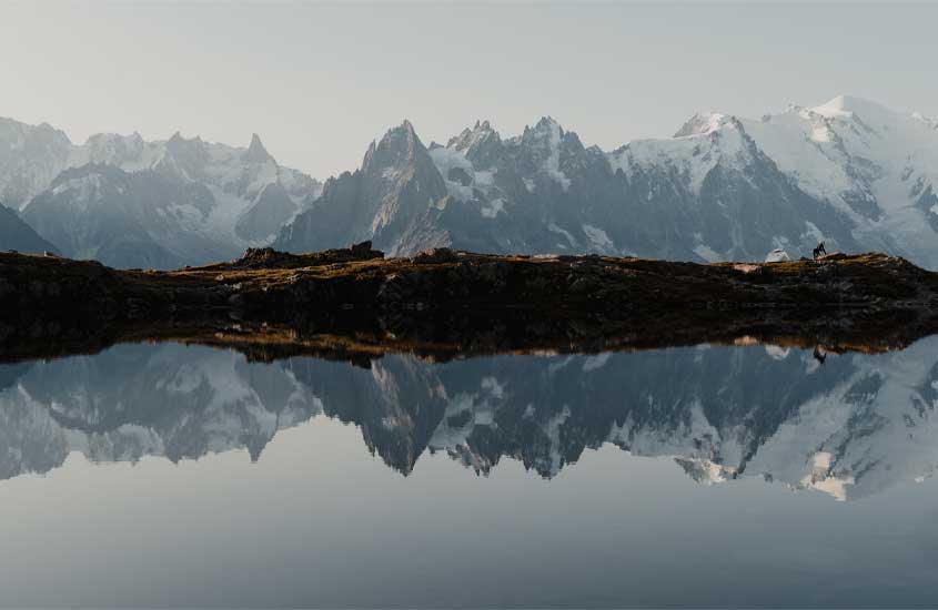 Durante a tarde, vista panorâmica dos alpes franceses refletidos na água
