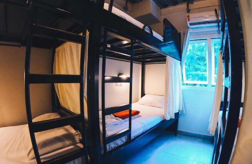 Quarto de hostel em copacabana barato com camas e janela acortinada