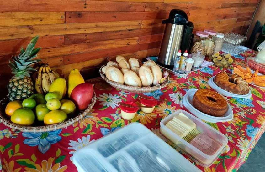 Mesa de café da manhã de uma pousada em itaunas com frutas, pães, bolos, frios, cafés e biscoitos