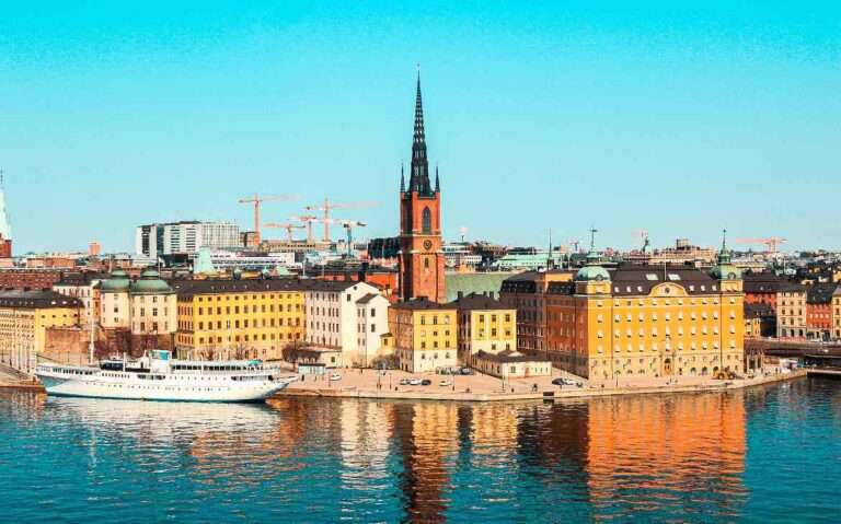 Em um dia ensolarado, vista aérea de prédios às margens do mar na cidade de Estocolmo