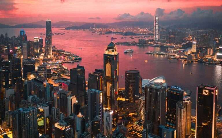 Durante o entardecer, vista aérea de Hong Kong China com vários prédios e mar na frente
