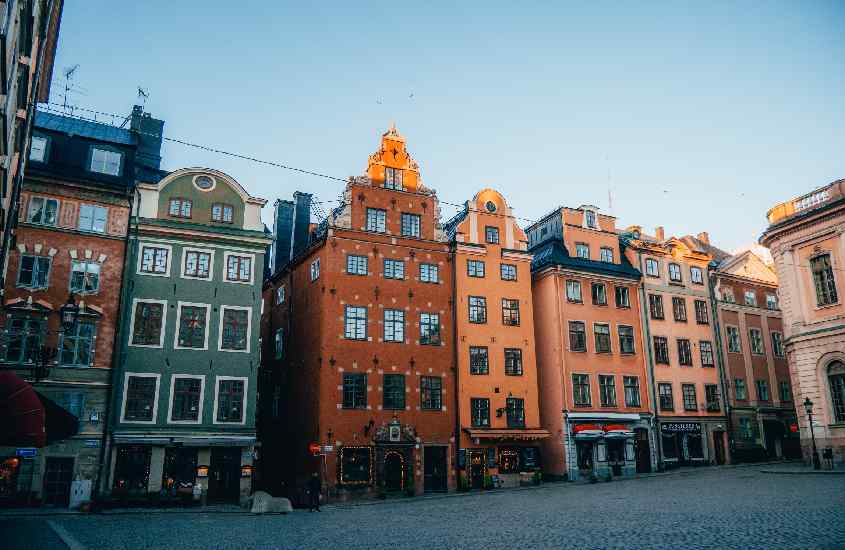Durante um dia de sol, fachada de alguns prédios coloridos onde ficar em Estocolmo