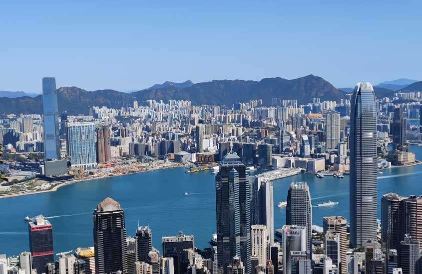 Em um dia de sol, vista aérea de Hong Kong China com vários prédios e mar na frente