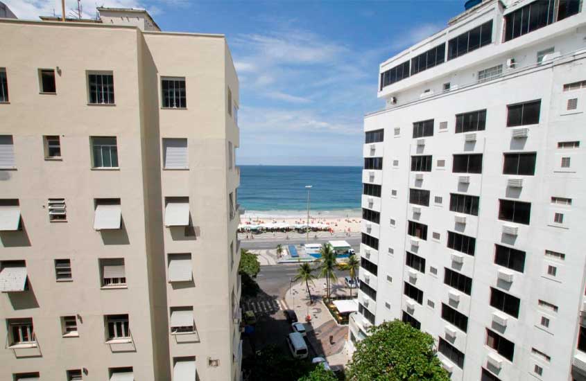 Em um dia de sol, horizonte de um dos hotéis em copacabana de frente para o mar com árvores e prédios em volta