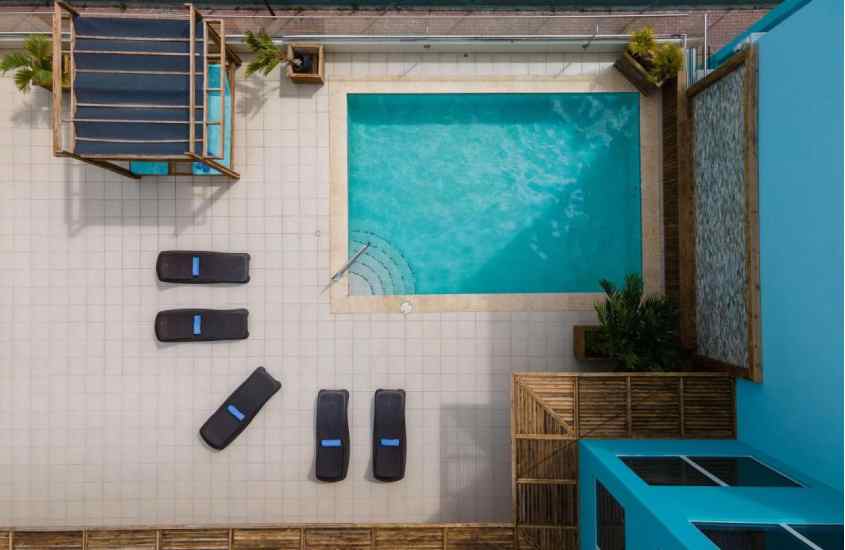 Vista aérea de área de lazer de um resort em curaçao com piscina, espreguiçadeiras e plantas decorativas