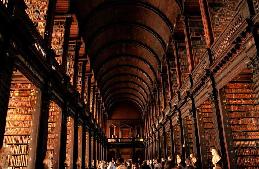 Livros em imponente biblioteca do Trinity College
