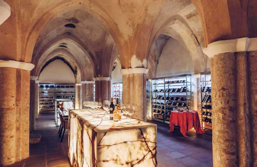 Adega de um Hotel vinícola Portugal com ilhas de mármore, cadeiras, mesas e decoração gótica