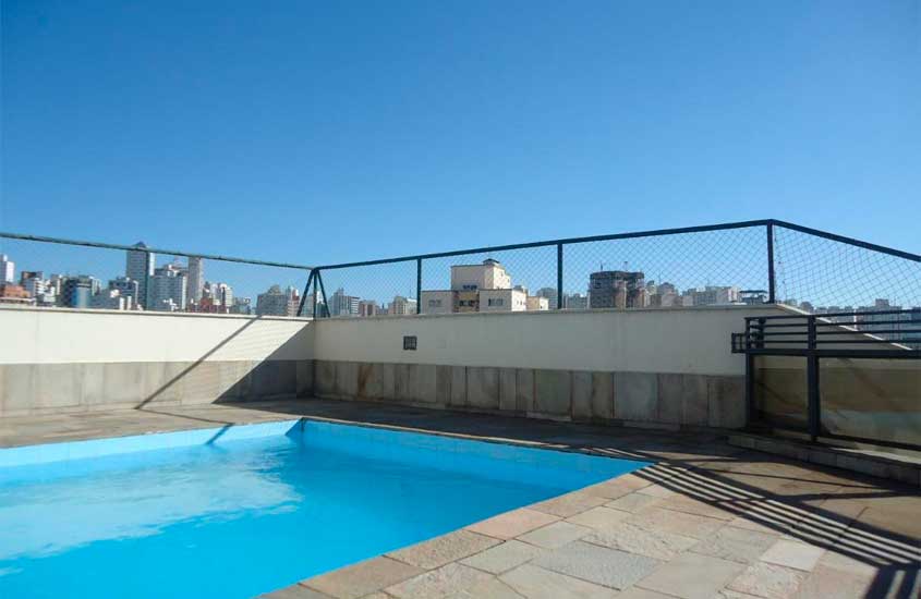 Em um dia de sol, área de lazer de um hotel em são paulo com piscina e vista da cidade