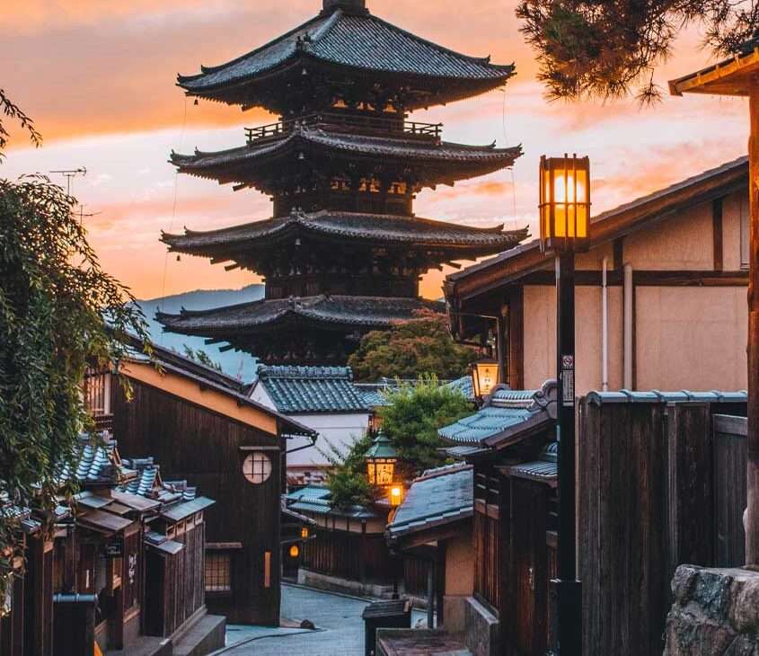 Durante o fim de tarde, templo em kyoto com árvores e casas na rua em volta