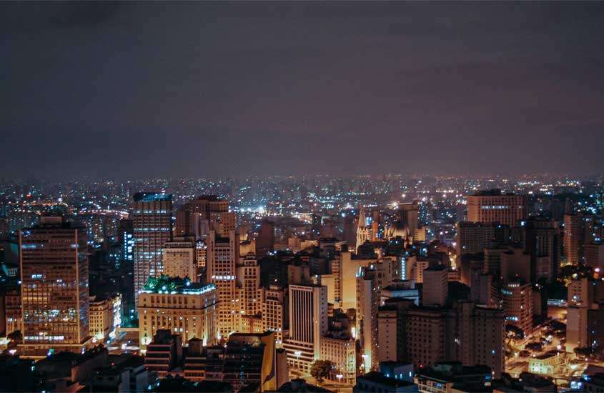 Durante a noite, vista aérea da cidade de São Paulo com prédios e ruas iluminadas