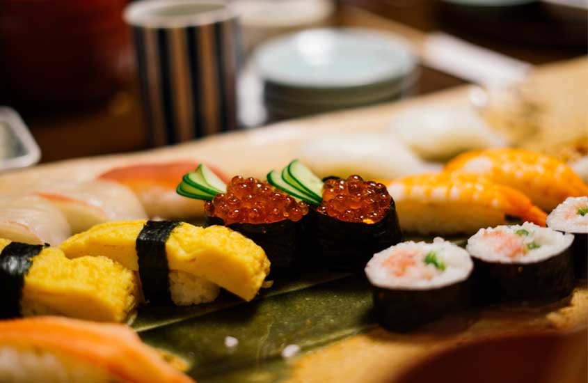 Mesa posta com sushis de peixe e pepino