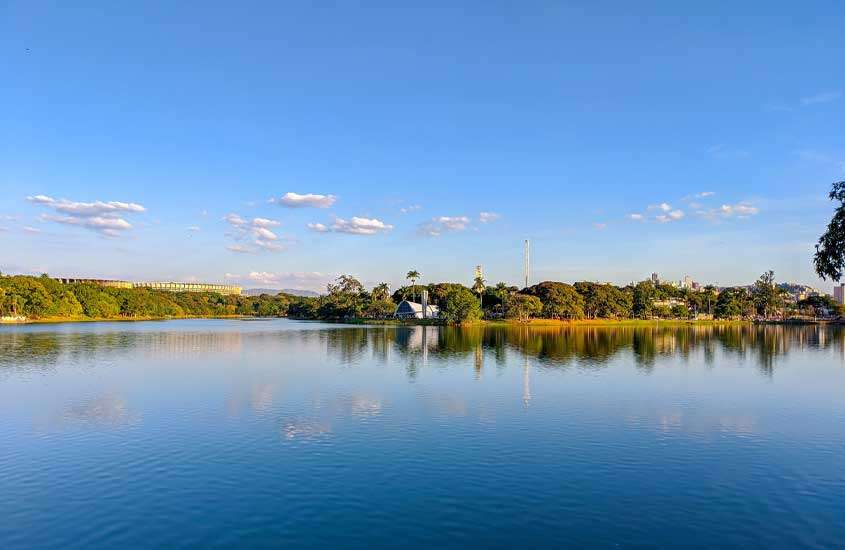 Em um dia de sol, igrejinha da lagoa da Pampulha em Belo Horizonte, um dos lugares baratos para passar o ano novo com árvores ao redor e céu com nuvens
