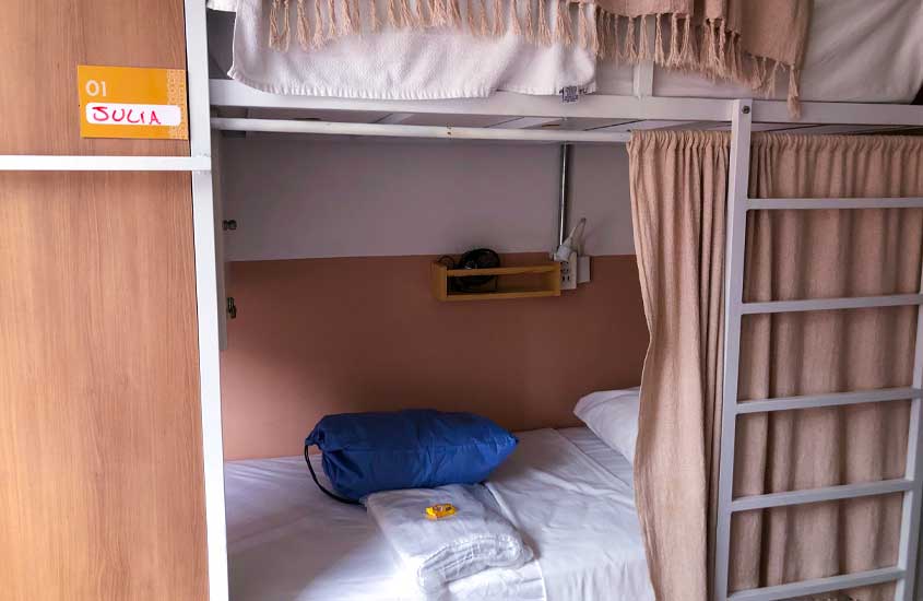 Cama de um quarto compartilhado do angatu hostel com kit de roupas de cama e tolhas