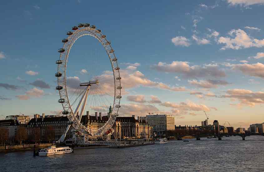 Em um final de tarde, roda gigante de Londres com o mar do lado e a cidade do outro