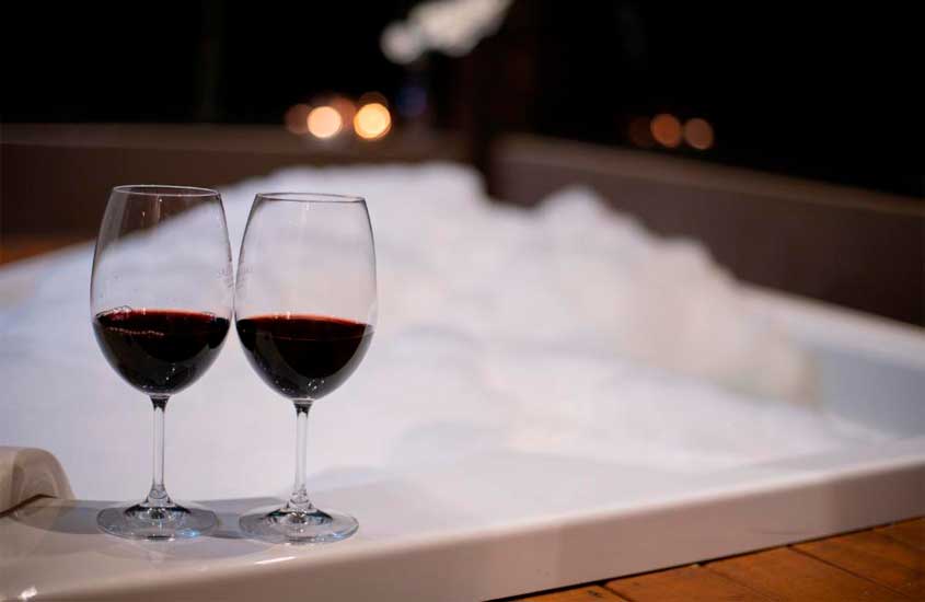 Área de banheira de um hotel com taças de vinho na ponta