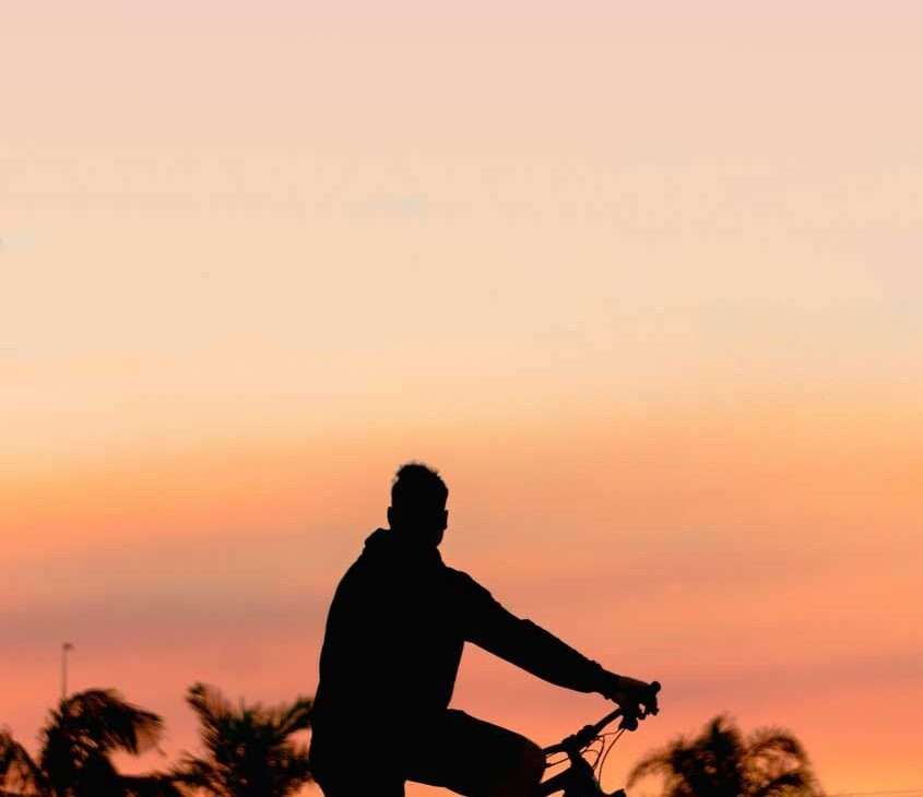 Em um final de tarde, home pedalando por um dos pontos turísticos de fort lauderdale com árvores atrás