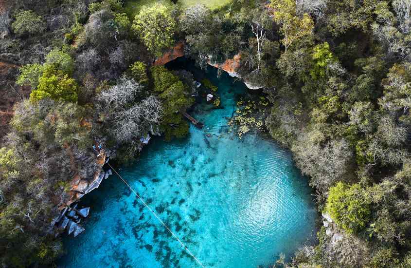 Vista aérea de uma lagoa com com pedras e árvores ao redor