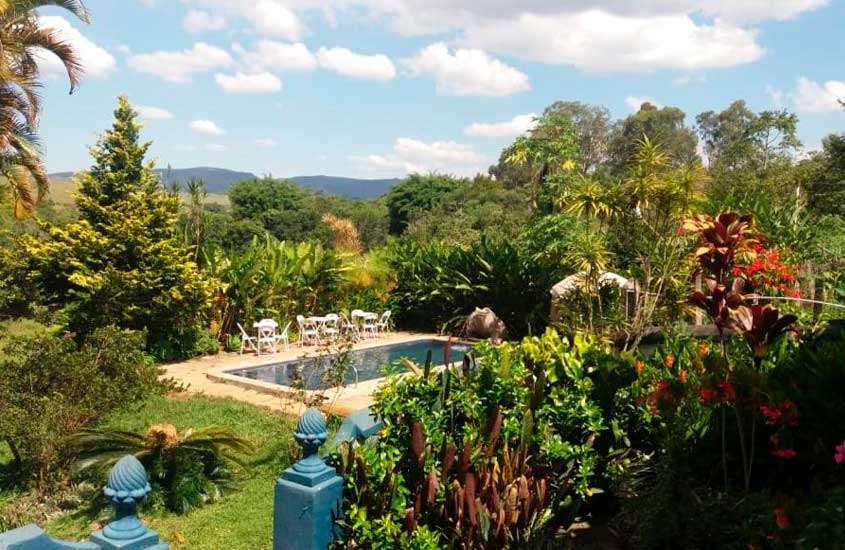 Durante uma manhã ensolarada, área de lazer de um dos melhores hotéis fazenda em minas gerais com piscinas, plantas, árvores e grama ao redor