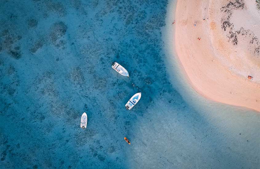 Vista aérea da praia das ilhas mauício com barcos no mar e faixa de areia do lado