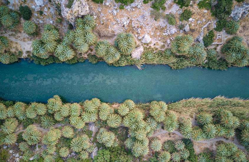 Visão aérea de um rio com árvores e pedras ao redor