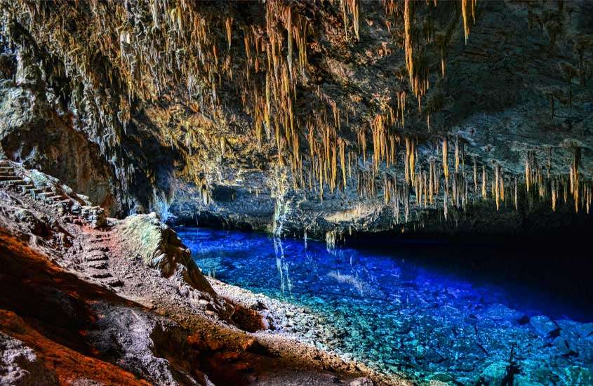 Interior de uma gruta em Bonito um lugar para onde viajar no feriado de corpus christi, com águas azuis e formações rochosas