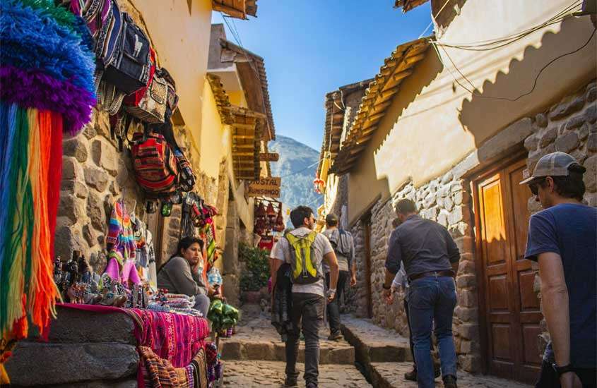 Durante um dia de sol, visitar os mercados da rua Loreto é um dos melhores passeios em cusco, com pessoas, produtos e vista da montanha no fundo