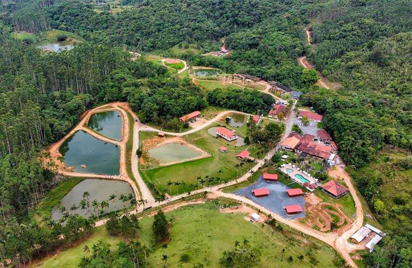 Vista aérea de um dos hotéis fazenda em santa catarina com lagos, parte gramada e árvores ao redor