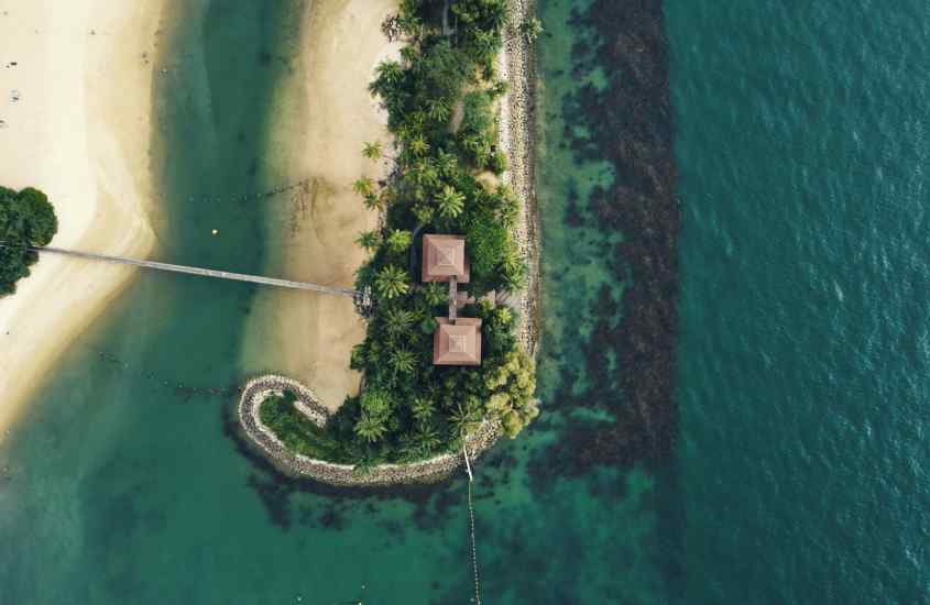 Vista aérea de um lugar onde ficar em singapura com mar e árvores ao redor