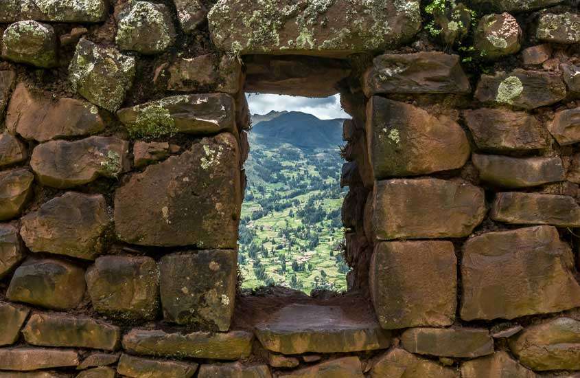 Uma das opções de o que fazer em cusco é visitar Pisac que tem u paredão de pedra com uma "janela" que da vista para as montanhas