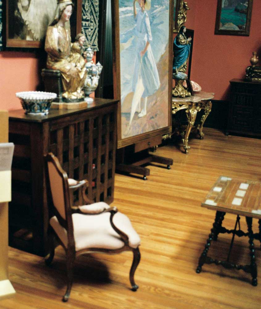 Interior de um dos museus de Madrid com cadeira, obras de arte e mesa