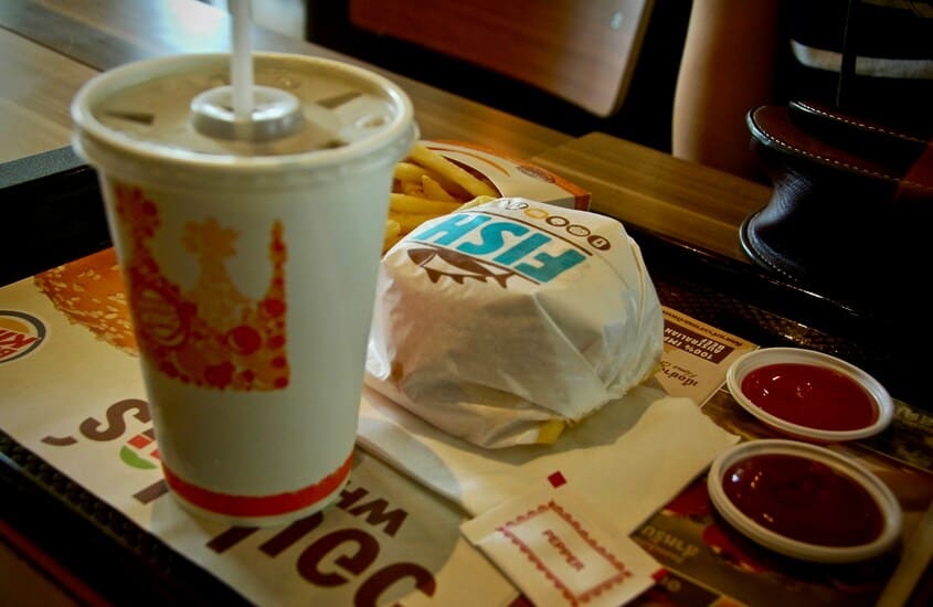 copo de refrigerante e hamburguer em cima de bandeja