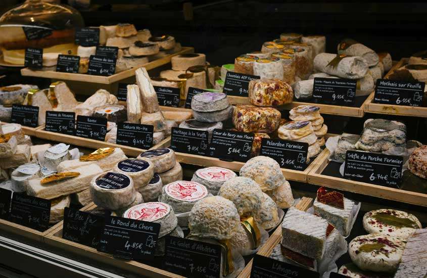 Mercado com diversos queijos que fazem parte da cultura francesa