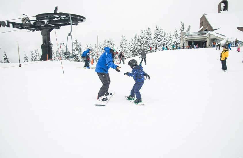Em um dia nevado, estação de esqui com pessoas, teleférico e árvores ao redor